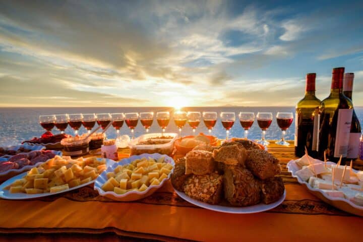 A dining table set up with food and drinks.