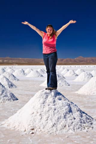 A tourist posing on top of a salt flat.