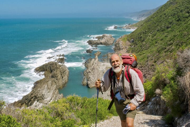 Happy old man just reaches the top of hill